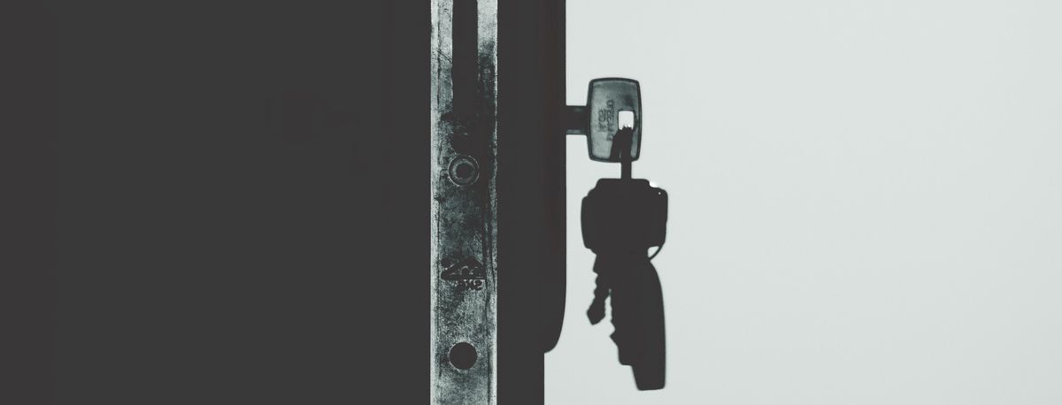 A monochrome door lock with a key.