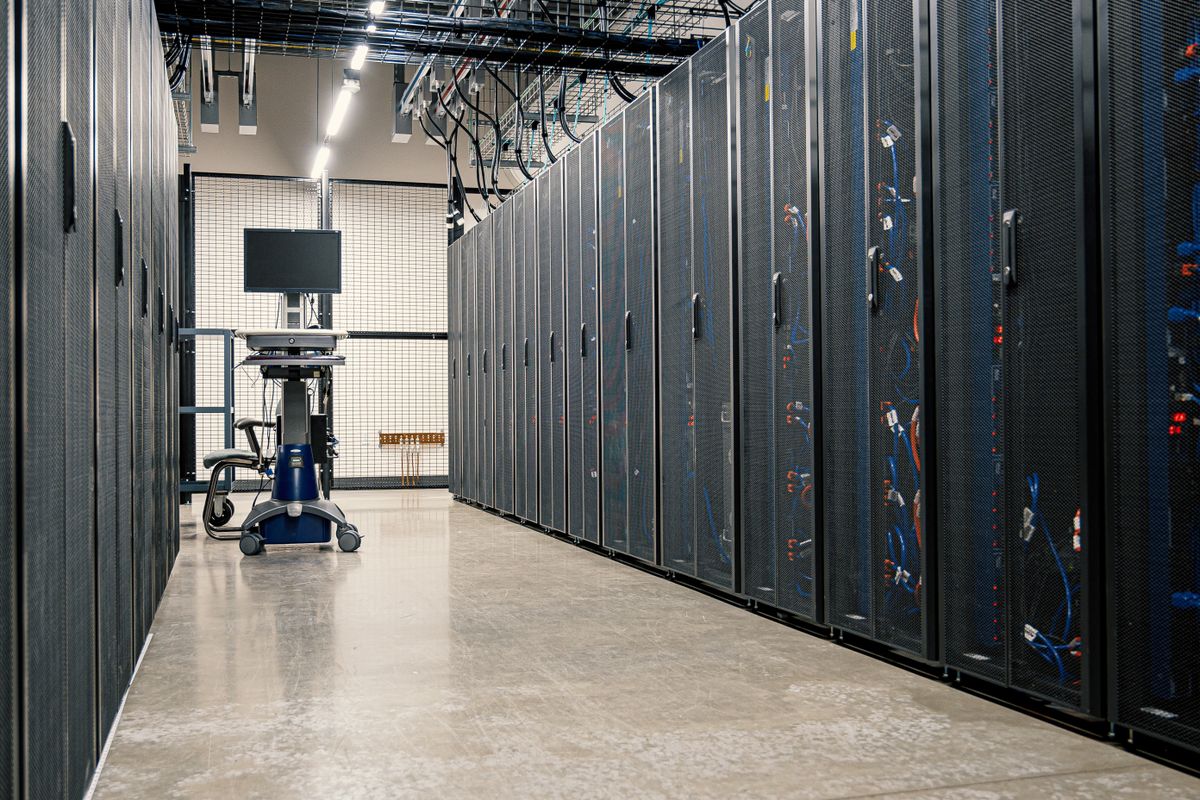 A monochrome corridor of server racks.