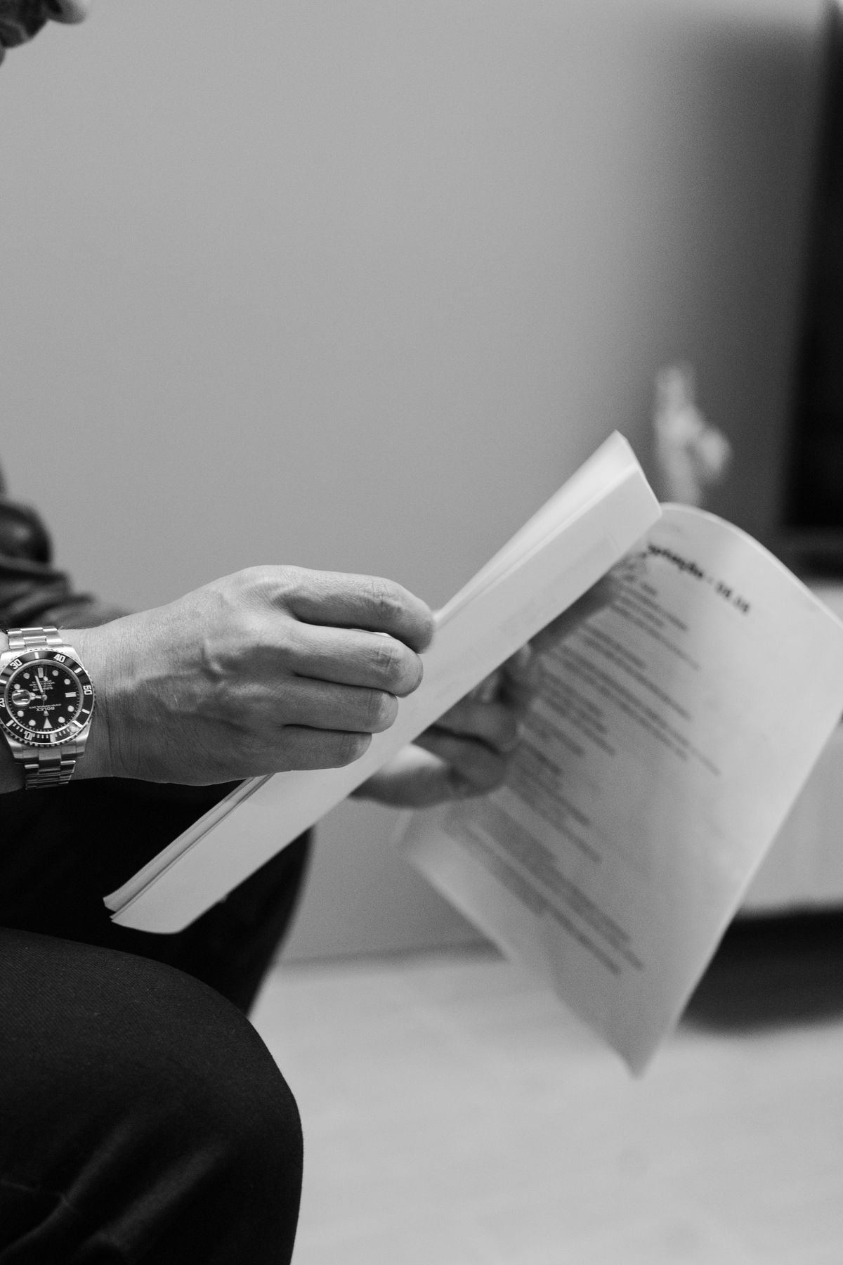 A monochrome close-up of documents being reviewed.