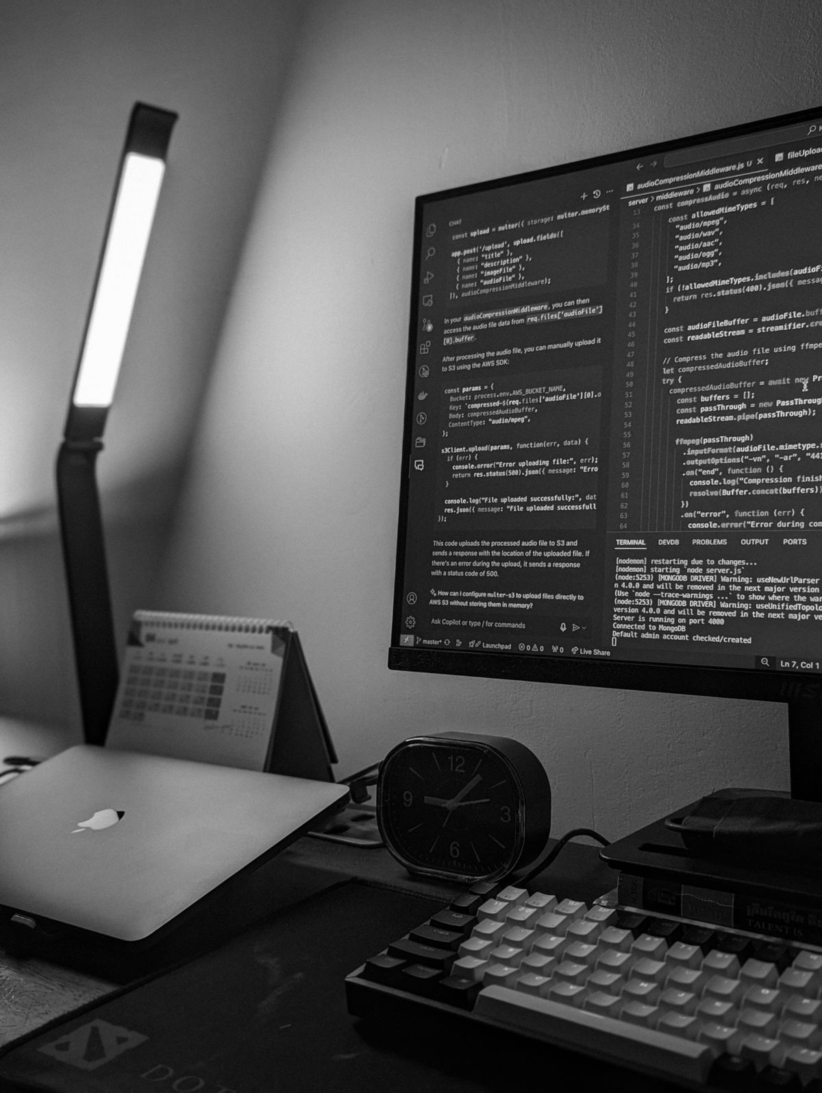 A monochrome workstation with a code editor on the screen.