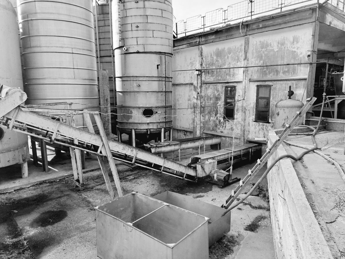 A monochrome industrial facility with connected machinery.