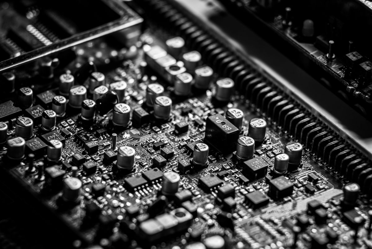 A monochrome circuit board with electronic components.